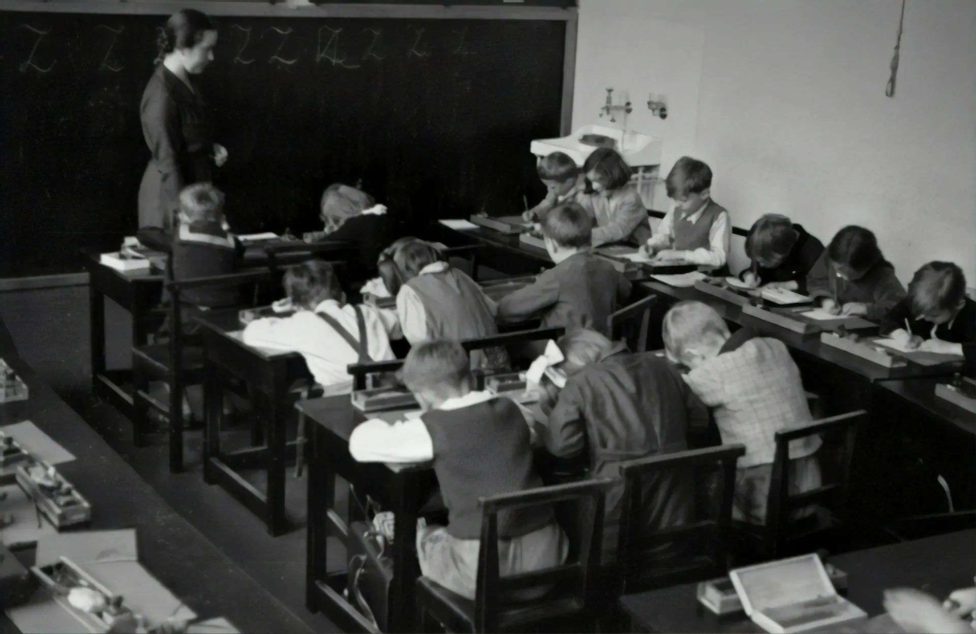 Teacher at a chalkboard with students learning in a classroom