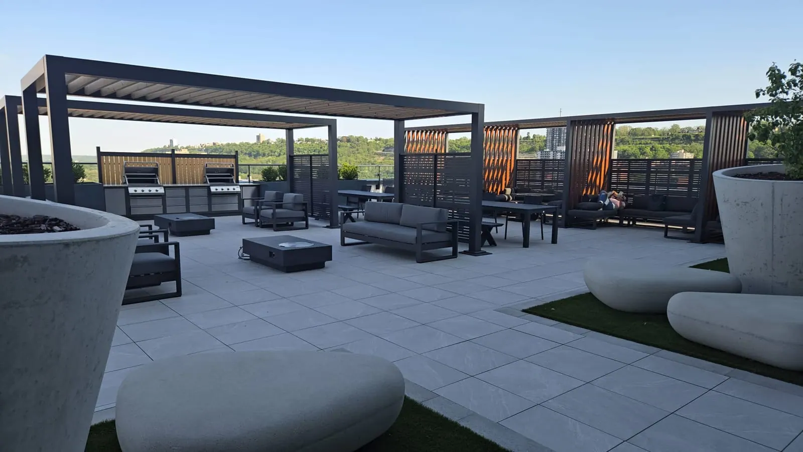 Rooftop terrace at dusk with lounge seating and a fire-pit table