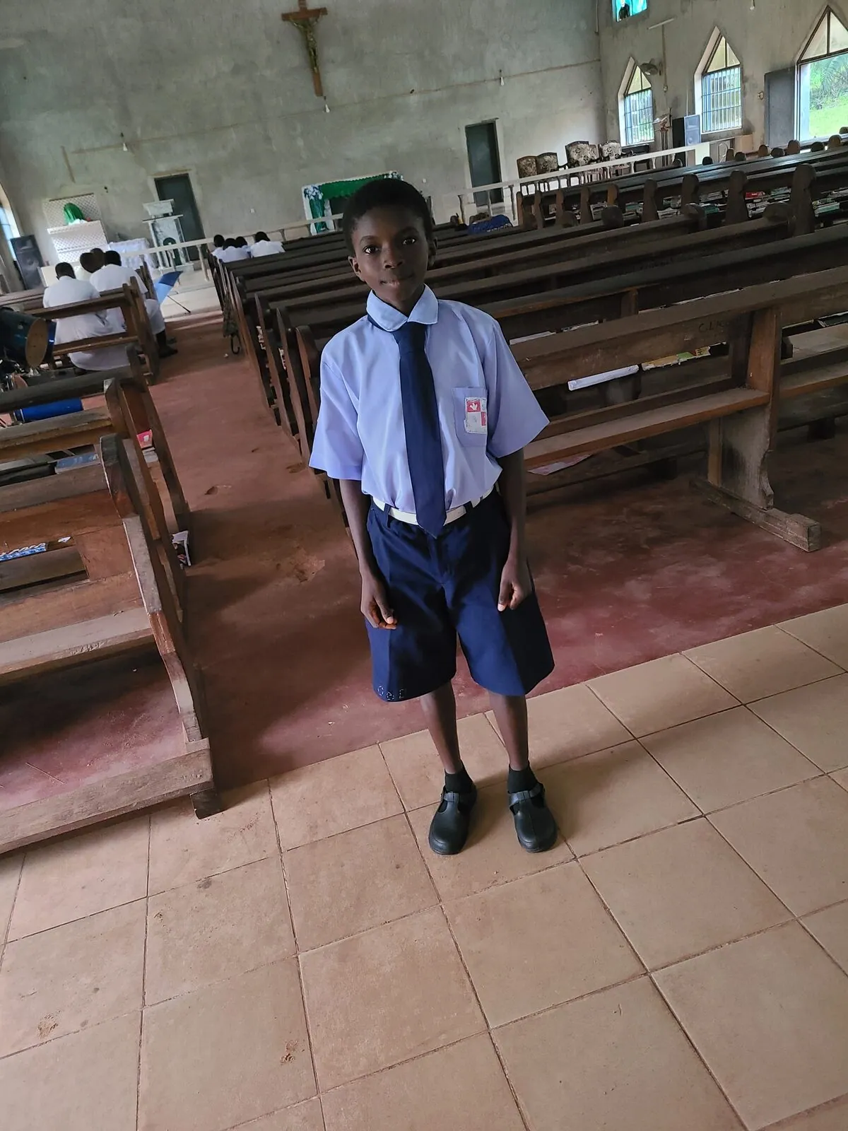 A sponsored student in school uniform inside her school chapel