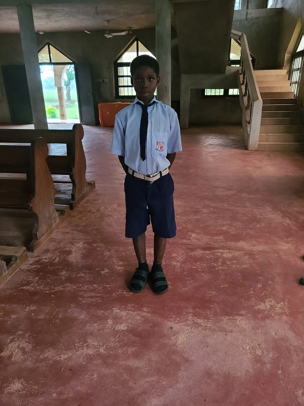 A sponsored student in uniform inside a school building
